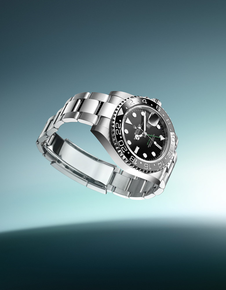 A stainless steel wristwatch with a black dial and rotating bezel is displayed against a gradient blue background.